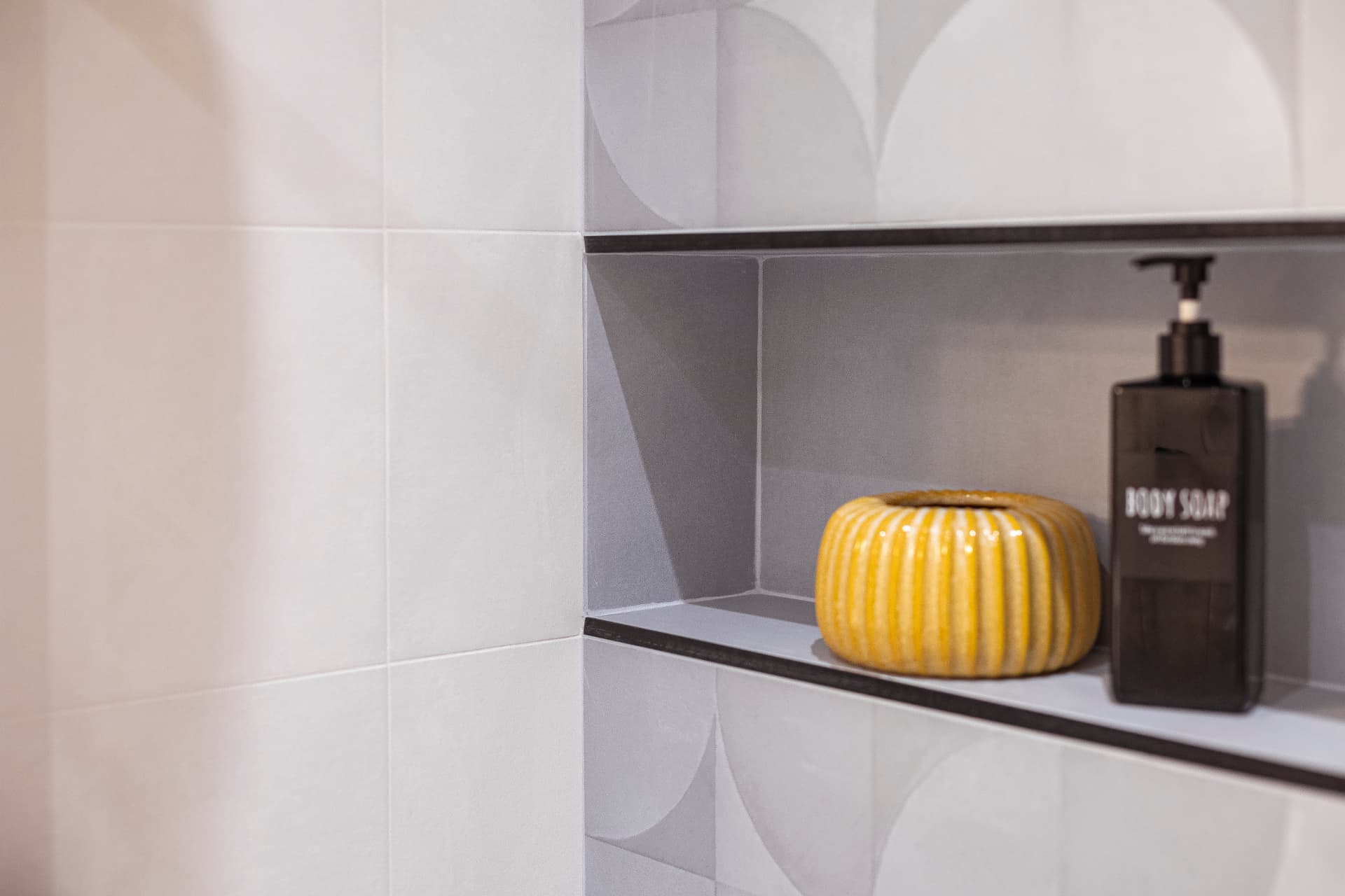Gros plan sur la niche de douche carrelée et ses accessoires Gros plan sur la niche de douche carrelée et ses accessoires