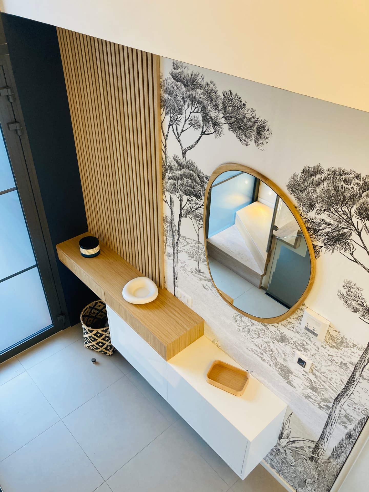 Console suspendue sur mesure et papier peint aux arbres dans une entrée Console suspendue sur mesure et papier peint aux arbres dans une entrée