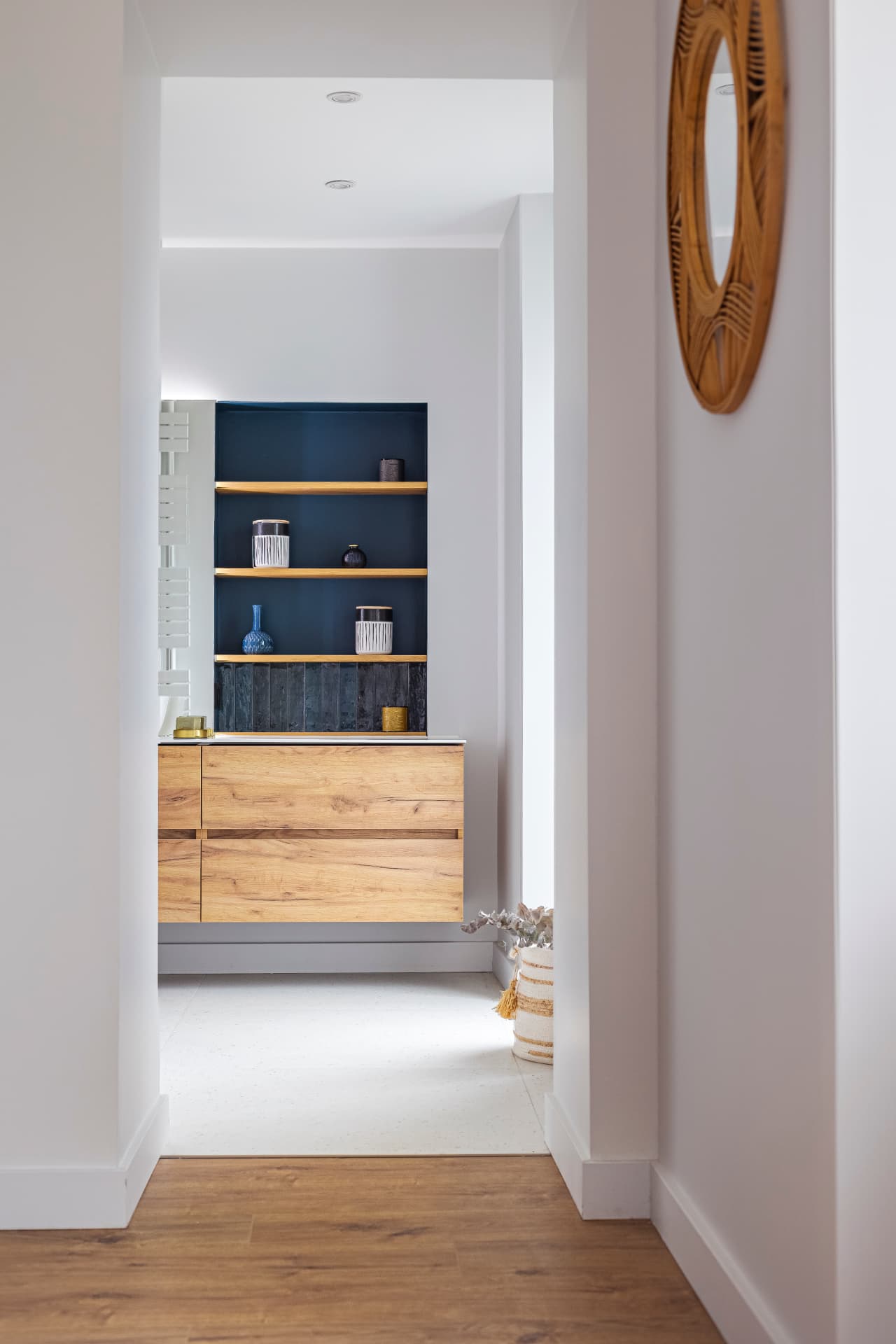 Perspective sur une salle de bain aux niches bleues depuis le couloir Perspective sur une salle de bain aux niches bleues depuis le couloir