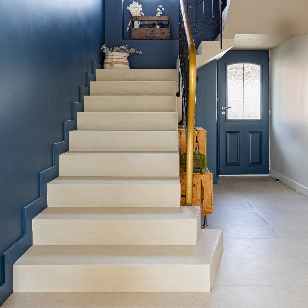 Entrée et escalier en béton ciré avec mur bleu profond Entrée et escalier en béton ciré avec mur bleu profond