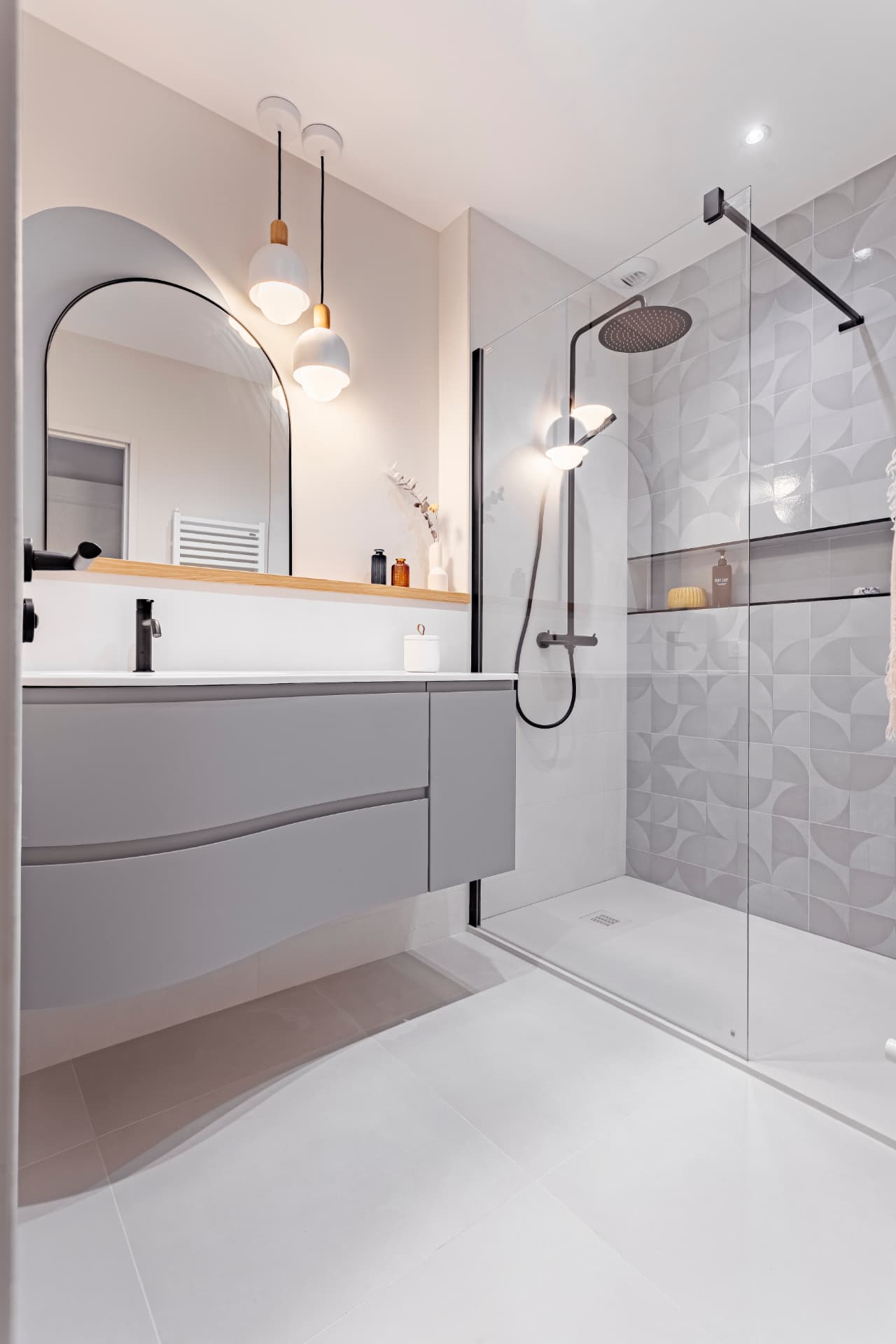 Salle de bain avec miroir en arche et tablette en chêne Salle de bain rénovée avec miroir en arche et tablette en chêne, projet de Lucie Hortala à La Réunion