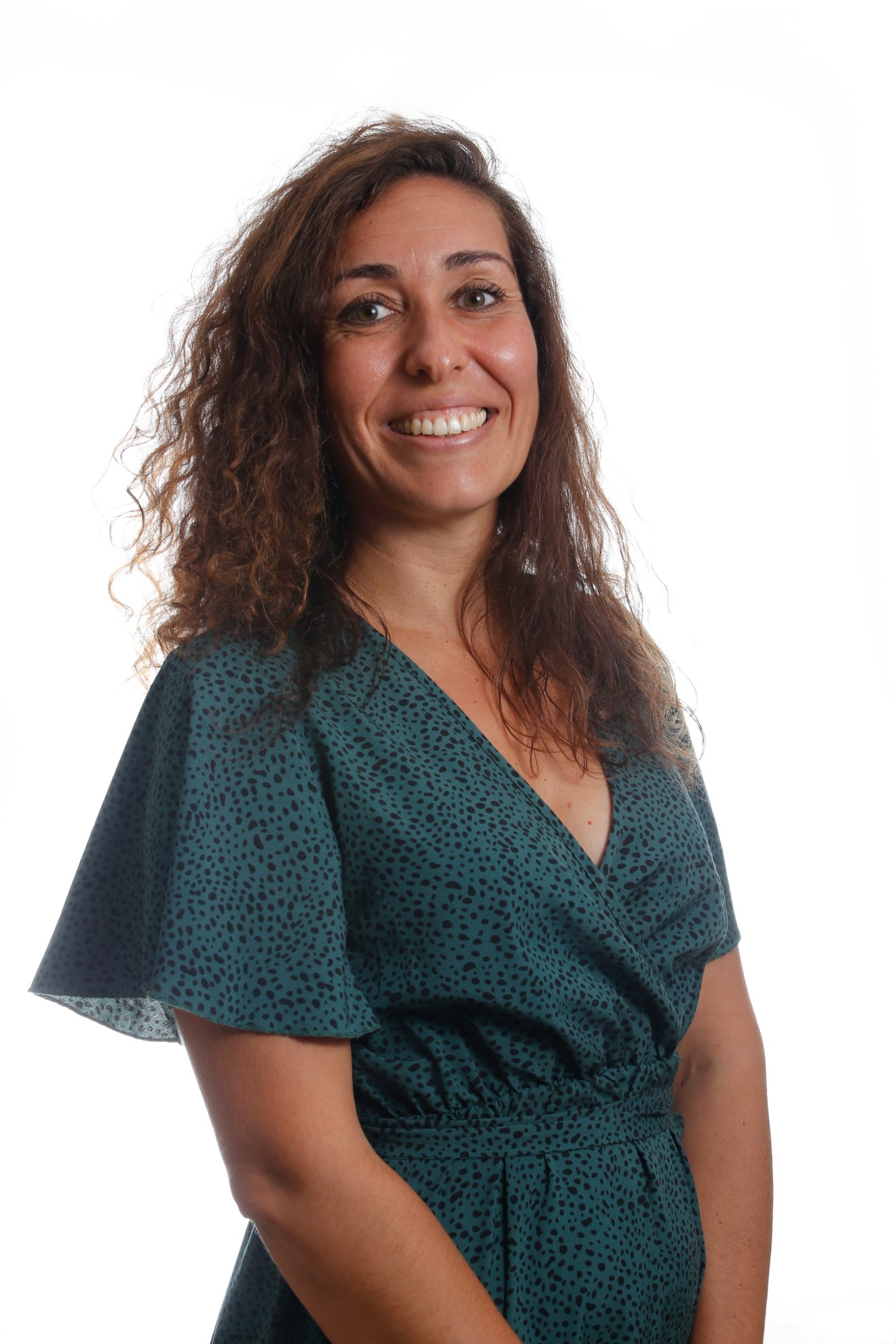 Lucie Hortala, architecte d'intérieur à La Réunion, en blouse verte à motifs sur fond blanc