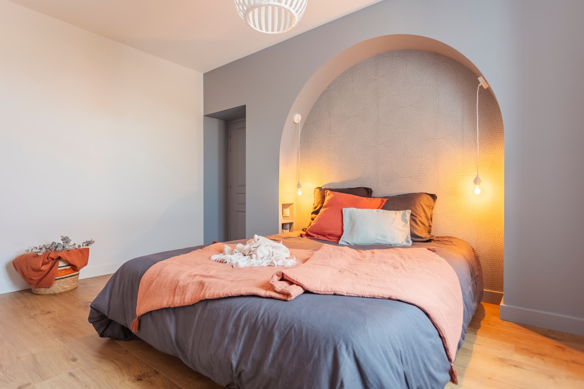 Chambre parentale avec tête de lit en arche, papier peint graphique et linge terracotta Chambre parentale avec tête de lit en arche, papier peint graphique et linge terracotta